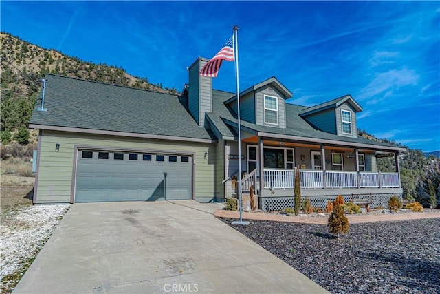 view of front of home featuring a mountain view, a porch, and a garage