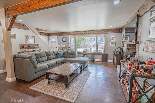 living room featuring dark wood-type flooring and a brick fireplace