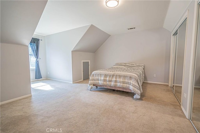 carpeted bedroom featuring lofted ceiling and a closet