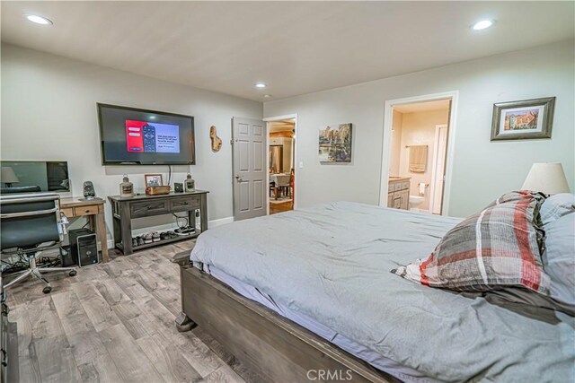 bedroom with ensuite bath and light hardwood / wood-style flooring