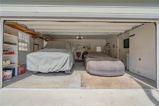 garage featuring strapped water heater and a garage door opener