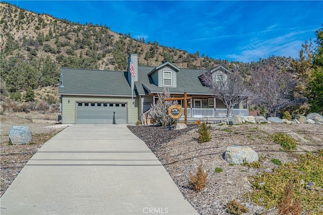 view of front of property with a mountain view, covered porch, and a garage