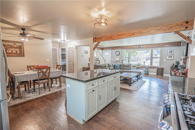 kitchen featuring a center island, dark hardwood / wood-style floors, ceiling fan, and dark stone counters