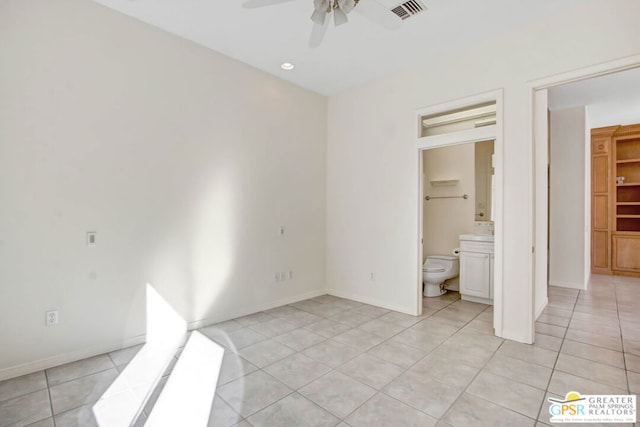 unfurnished bedroom featuring connected bathroom, light tile patterned floors, and ceiling fan