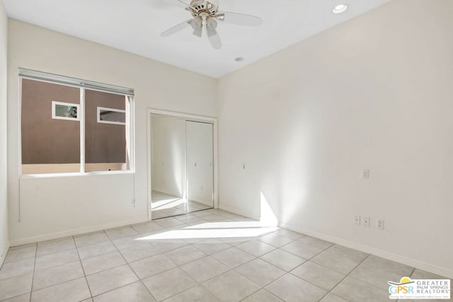 tiled spare room featuring ceiling fan