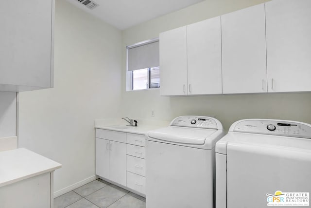 laundry area featuring cabinets, light tile patterned flooring, washer and dryer, and sink