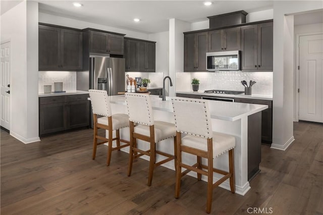 13634 Shannon St, Moreno Valley, CA 92555 - kitchen featuring appliances with stainless steel finishes, dark hardwood / wood-style flooring, a kitchen island with sink, and a breakfast bar area