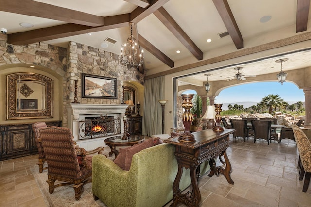 living room with lofted ceiling with beams and ceiling fan with notable chandelier