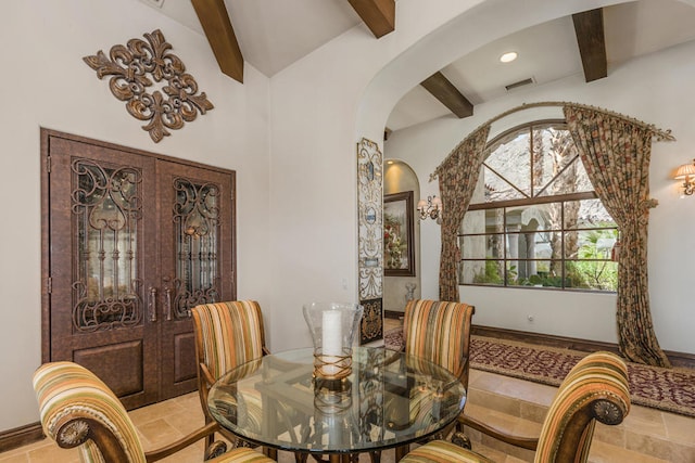 dining space featuring french doors and beamed ceiling