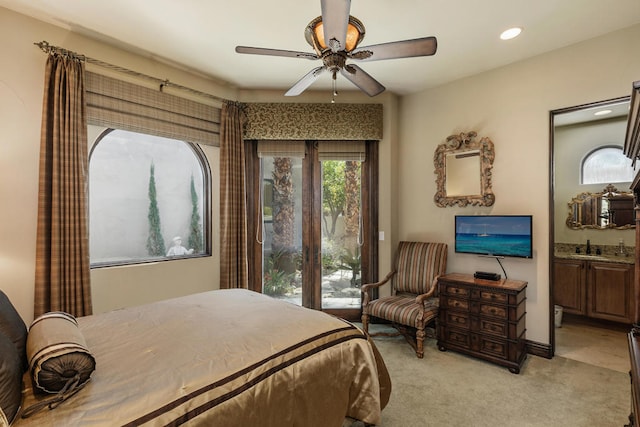 carpeted bedroom featuring ensuite bath and ceiling fan