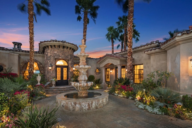 patio terrace at dusk featuring french doors