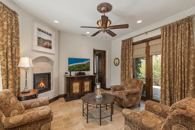 living room featuring french doors, a tiled fireplace, and ceiling fan