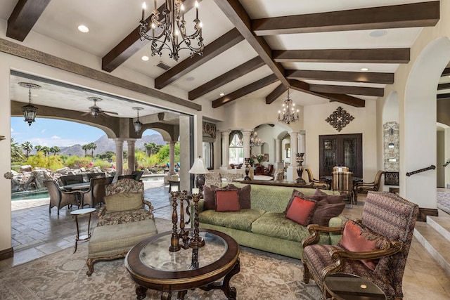 living room featuring decorative columns, lofted ceiling with beams, and ceiling fan with notable chandelier