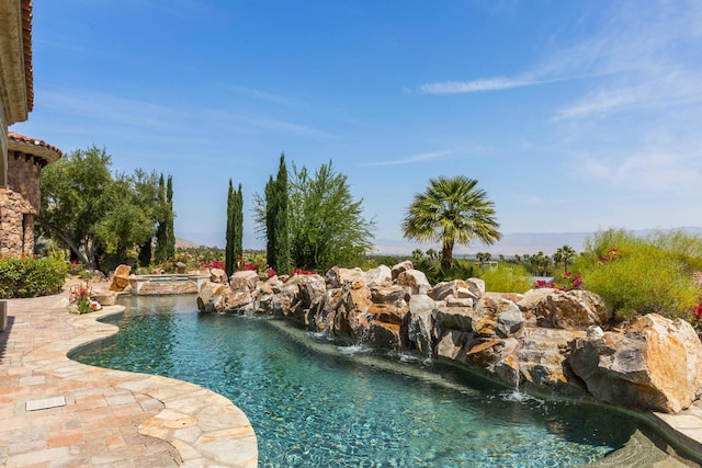 view of swimming pool with an in ground hot tub, a patio, and pool water feature