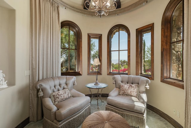 sitting room featuring a notable chandelier and carpet flooring