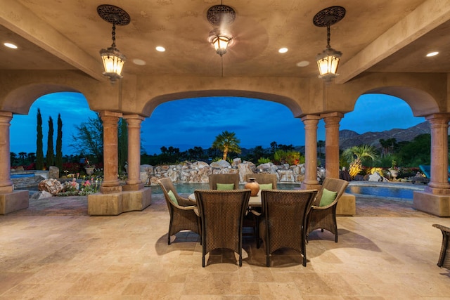 patio terrace at dusk featuring a mountain view