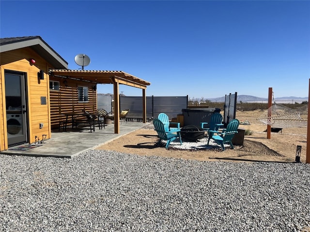 view of yard featuring a patio, a pergola, an outdoor fire pit, and a mountain view