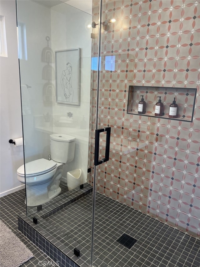 bathroom with toilet, a shower with shower door, and tile patterned flooring