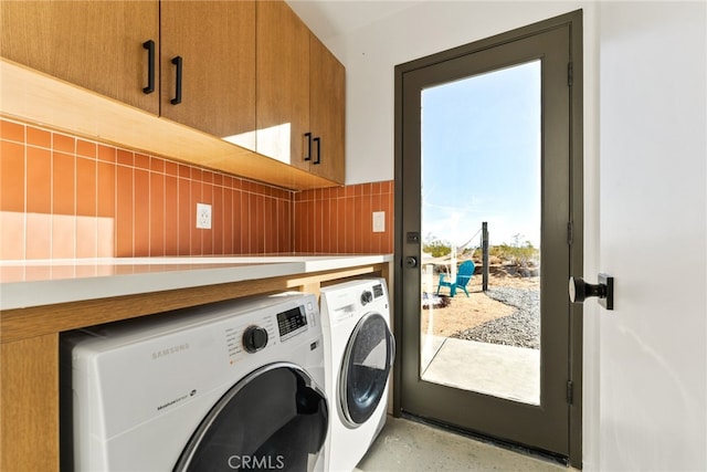 washroom featuring a wealth of natural light, washing machine and dryer, and cabinets