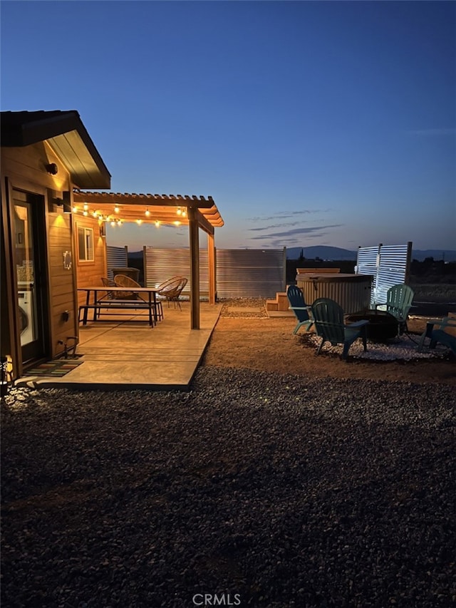 yard at dusk with a pergola and a patio area