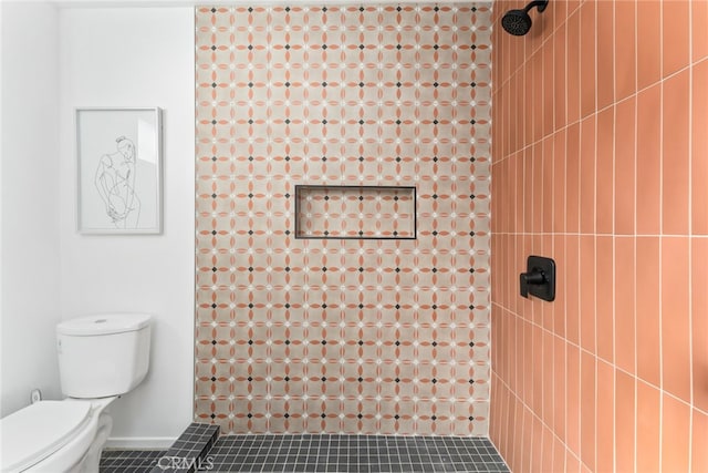 bathroom featuring a tile shower, toilet, and tile patterned floors