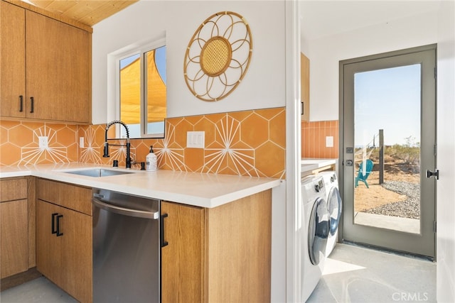 kitchen with plenty of natural light, stainless steel dishwasher, sink, and washing machine and dryer