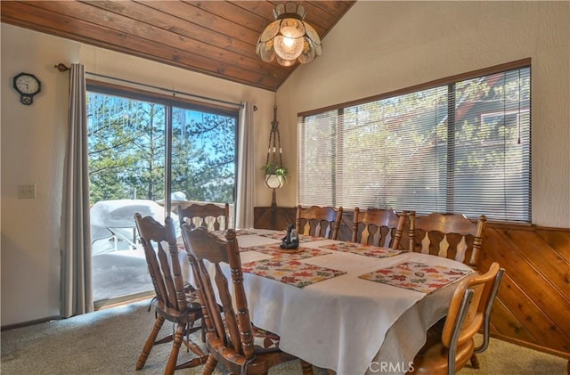 carpeted dining area featuring lofted ceiling and wooden ceiling