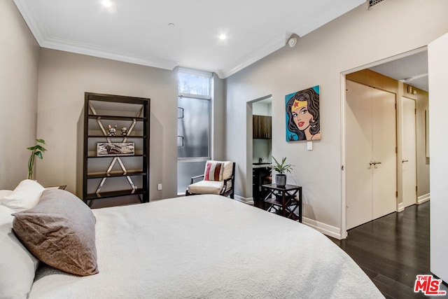 bedroom featuring ornamental molding and dark hardwood / wood-style flooring