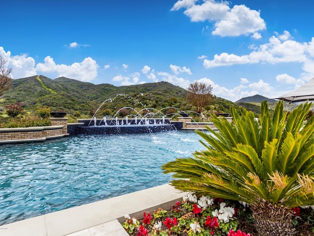 view of swimming pool with a mountain view