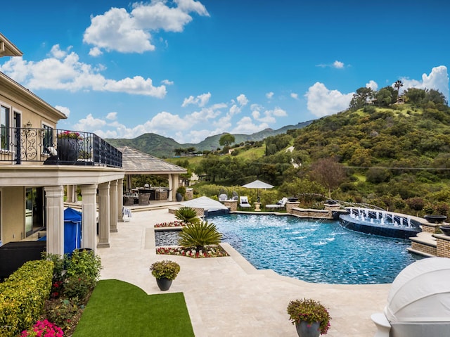 view of swimming pool featuring a hot tub, a patio, a gazebo, pool water feature, and a mountain view