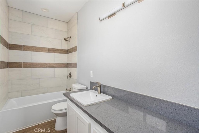 full bathroom featuring hardwood / wood-style floors, vanity, toilet, and tiled shower / bath combo