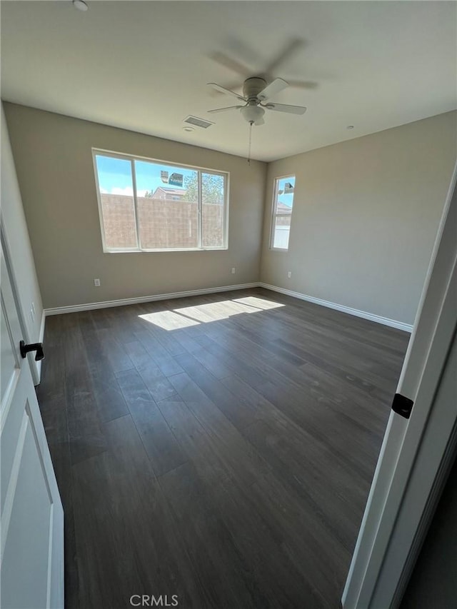 spare room featuring ceiling fan and dark hardwood / wood-style flooring