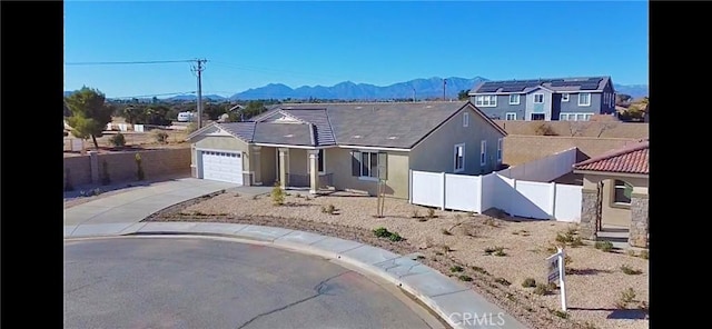 view of front of property with a garage and a mountain view