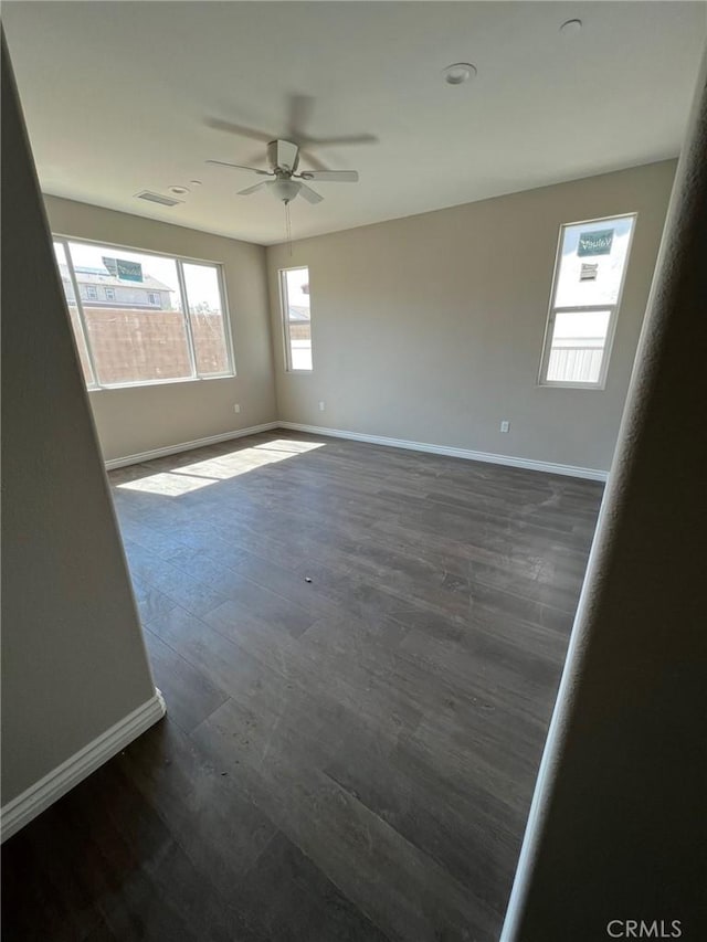 spare room featuring ceiling fan and dark hardwood / wood-style floors