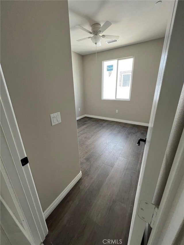 empty room featuring ceiling fan and dark hardwood / wood-style flooring