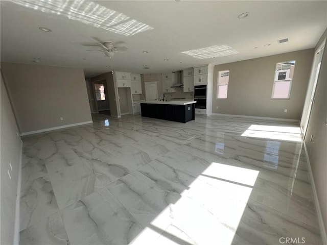 unfurnished living room with ceiling fan