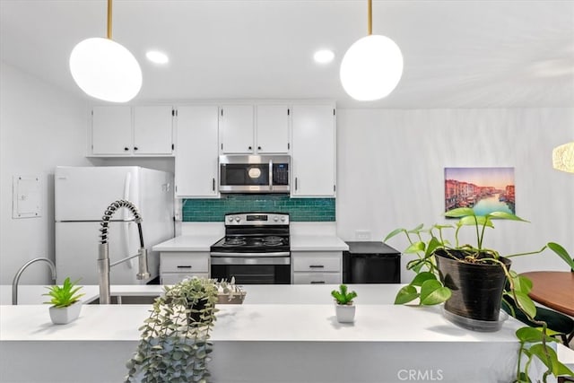 kitchen featuring appliances with stainless steel finishes, decorative backsplash, pendant lighting, and white cabinets