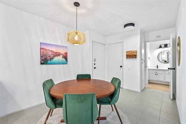 dining space featuring sink and light tile patterned floors