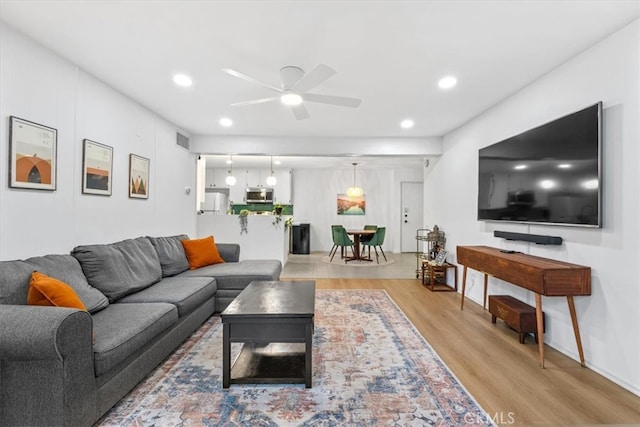 living room featuring ceiling fan and light wood-type flooring