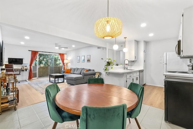 dining room with light hardwood / wood-style floors, sink, and ceiling fan