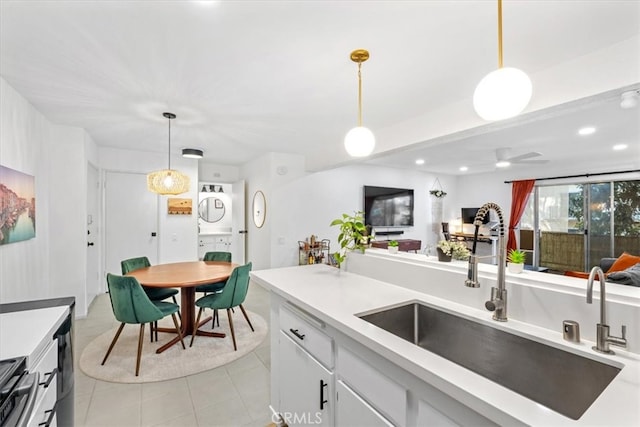 kitchen featuring decorative light fixtures, sink, light tile patterned floors, and white cabinets