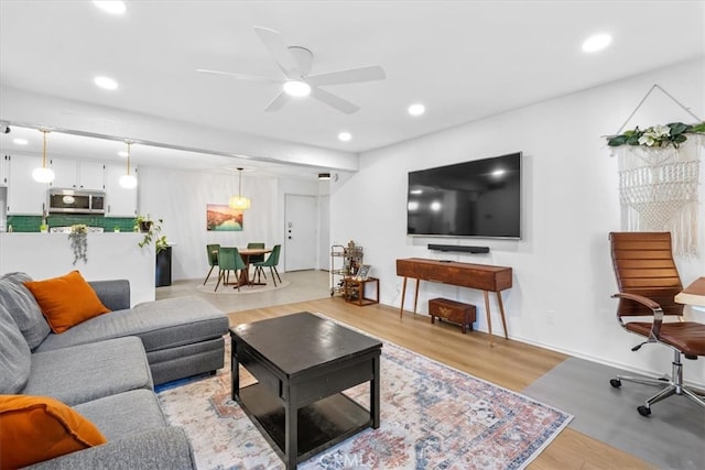 living room featuring light hardwood / wood-style floors and ceiling fan