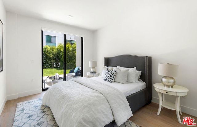 bedroom with access to outside and light wood-type flooring