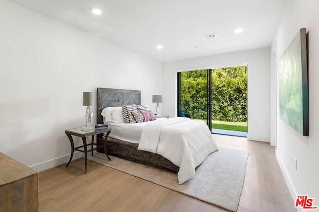 bedroom with access to exterior and light hardwood / wood-style flooring