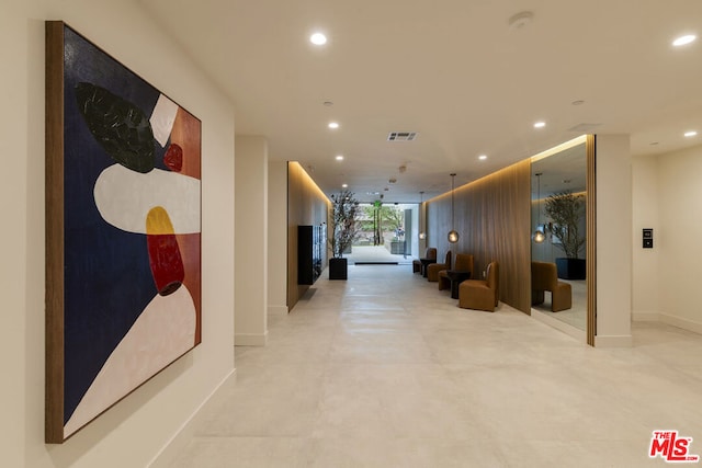 hall with wood walls and expansive windows