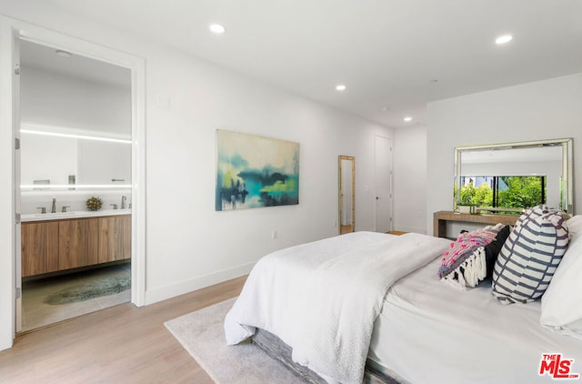 bedroom with light hardwood / wood-style floors and sink