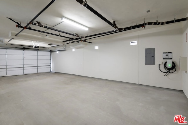 garage featuring electric panel and a garage door opener