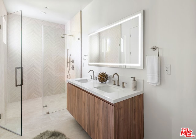 bathroom with a shower with door, vanity, and tile patterned floors