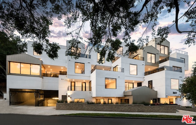 back house at dusk with a balcony