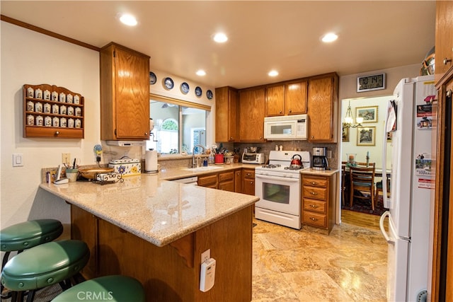 kitchen with tasteful backsplash, kitchen peninsula, sink, and white appliances